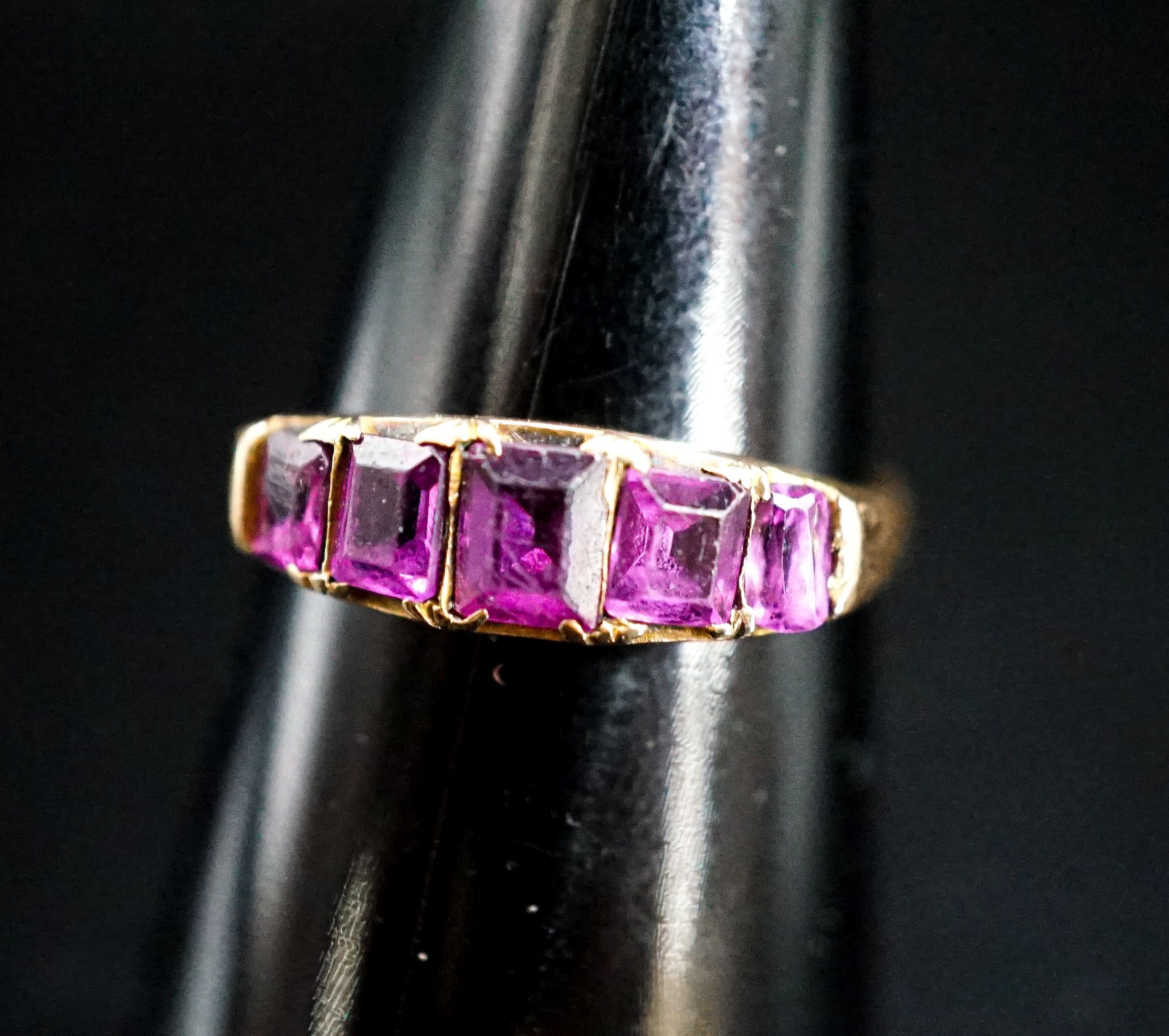 A Victorian 15ct gold and graduated five stone amethyst paste set half hoop ring, size O/P, gross 2.4 grams.